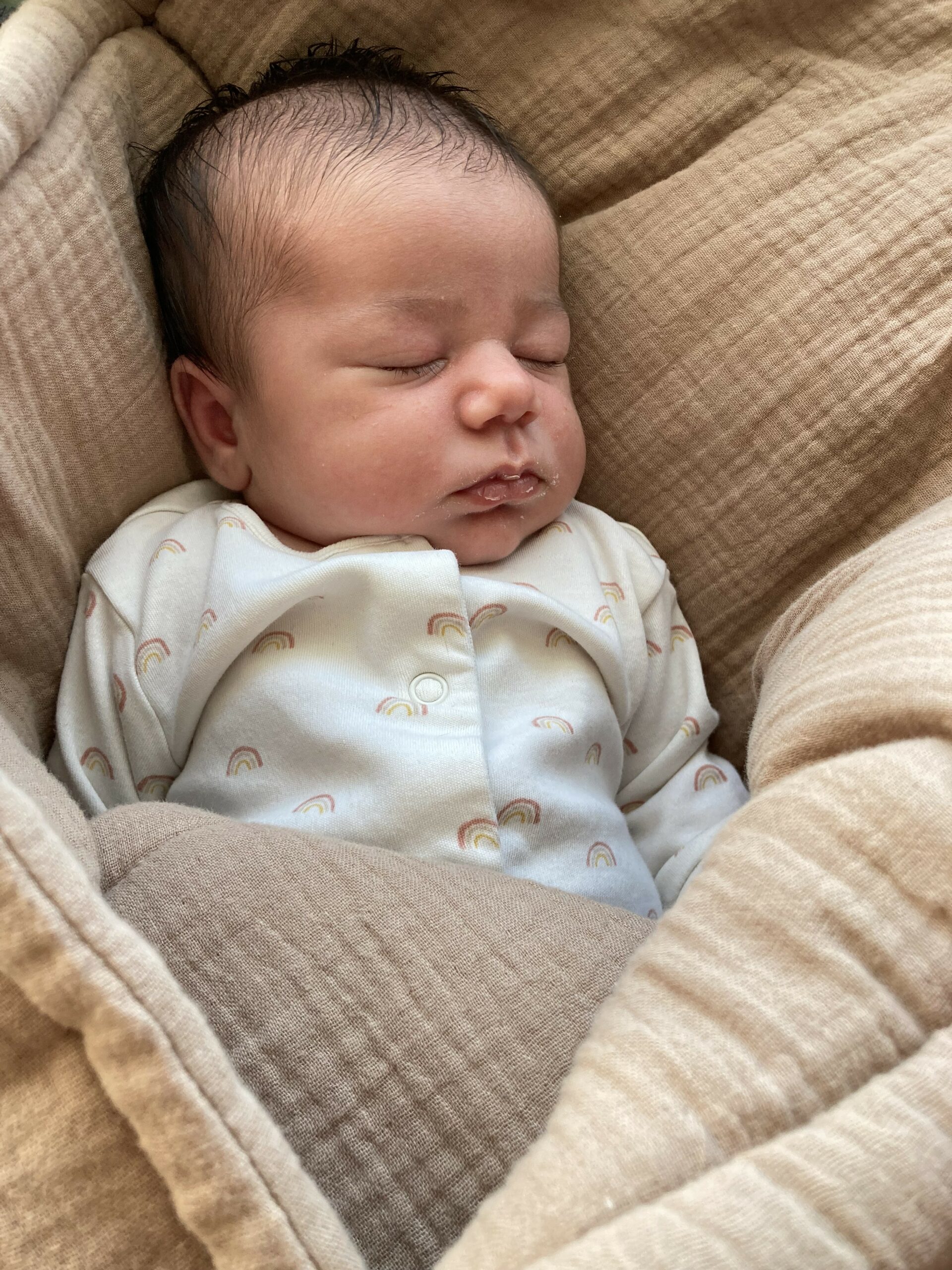 Novorozené miminko spící v péřové peřince